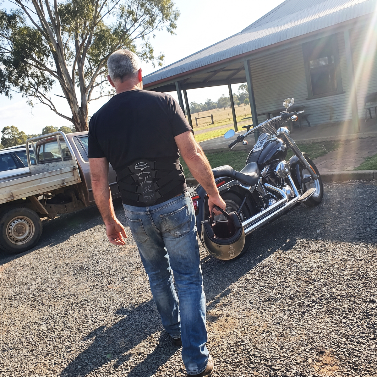 Rider walking to his cruiser outside a country pub wearing MotoSupport