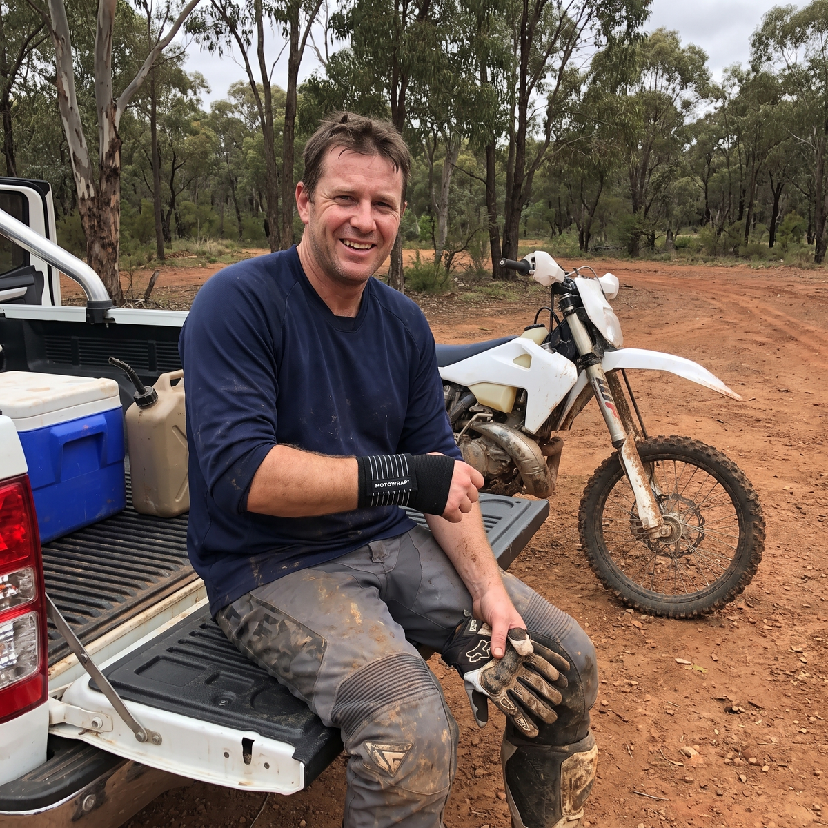 Dirt bike rider on a ute tailgate wearing a MotoWrap wrist support